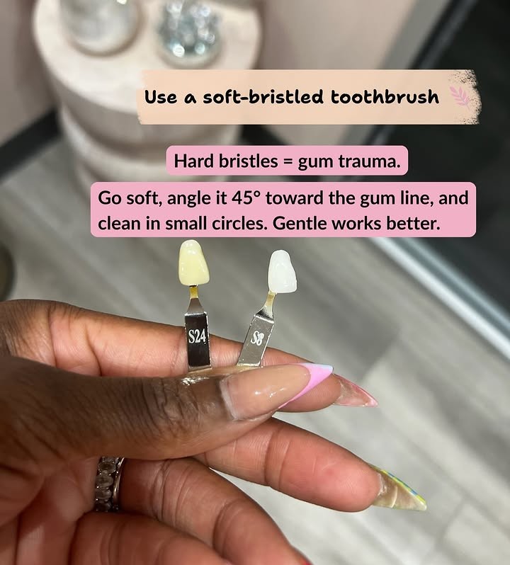 Hand holding two dental shade guide tabs for comparison